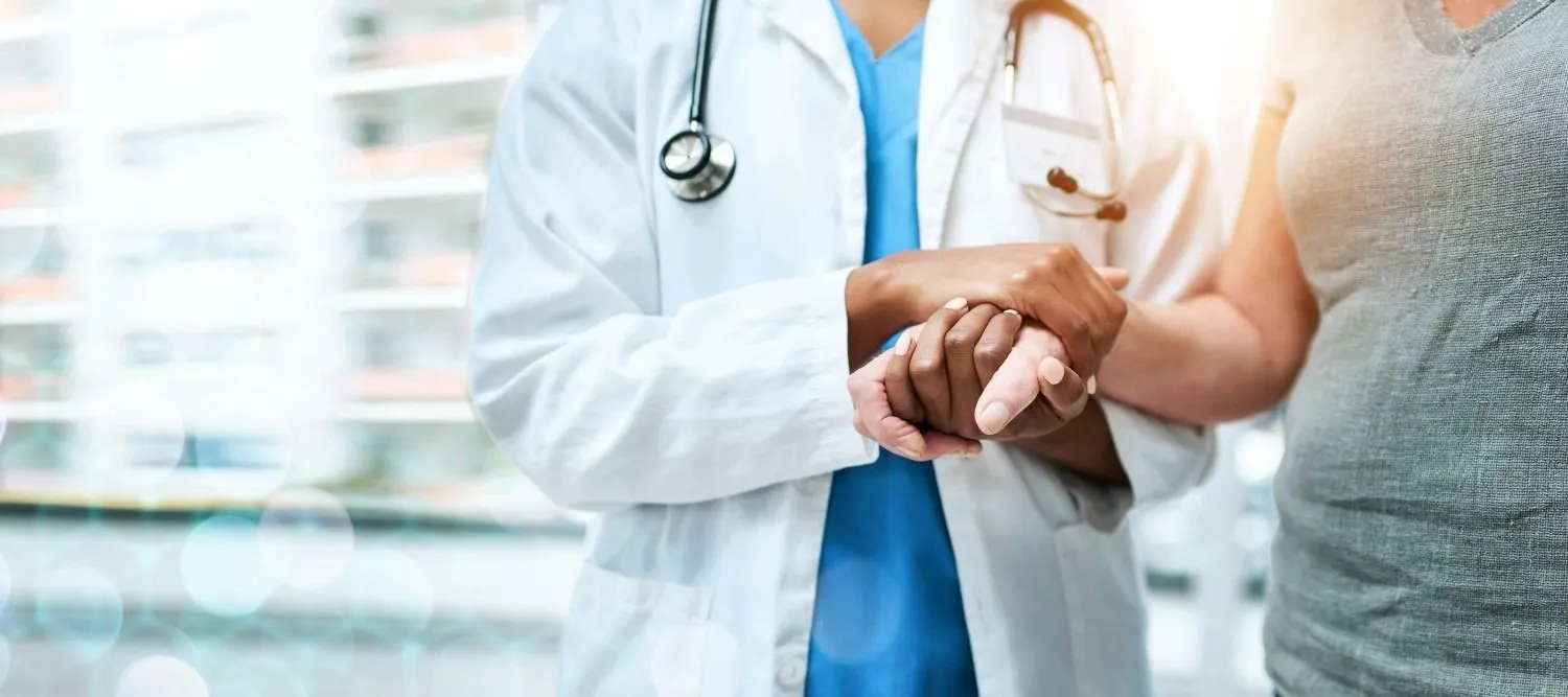 A doctor sitting with an older man during a health visit at home